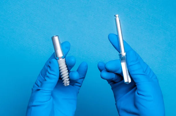 Hands in blue gloves holding dental implant tools — Stock Photo, Image