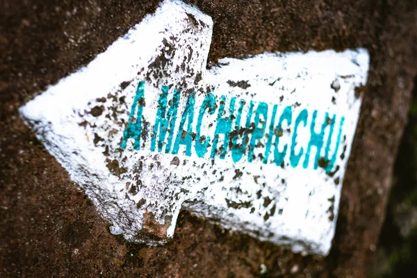 Sinal de seta apontando branco para Machupicchu na rocha — Fotografia de Stock