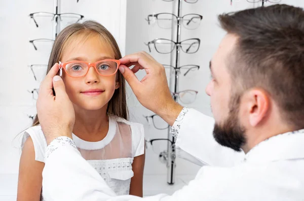 Chica y médico elegir gafas — Foto de Stock