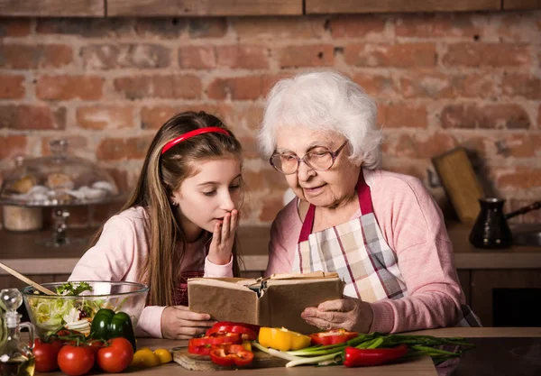Бабуся з внучки використанням приготування книги — стокове фото