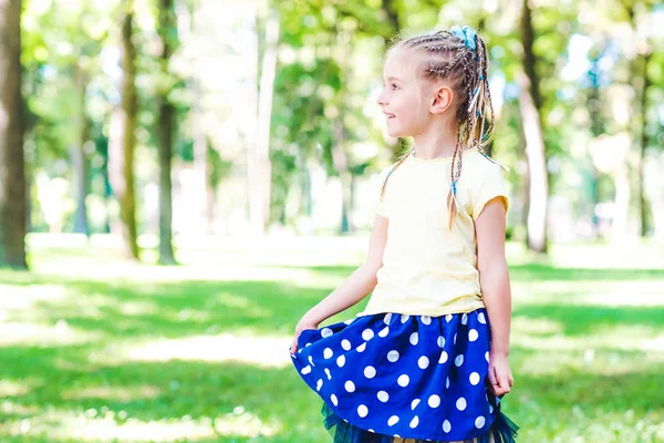 Malá usměvavá dívka v parku — Stock fotografie