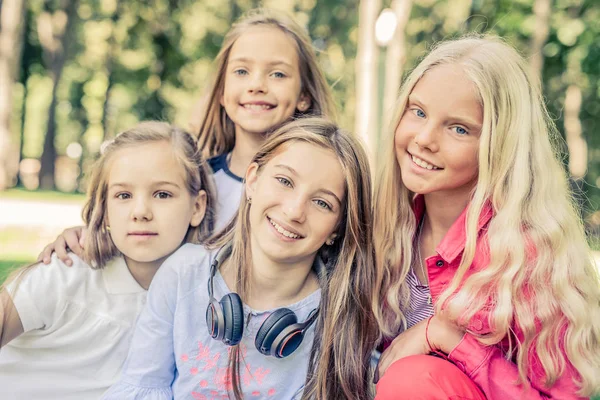 Ganska leende små flickor står tillsammans i parken — Stockfoto