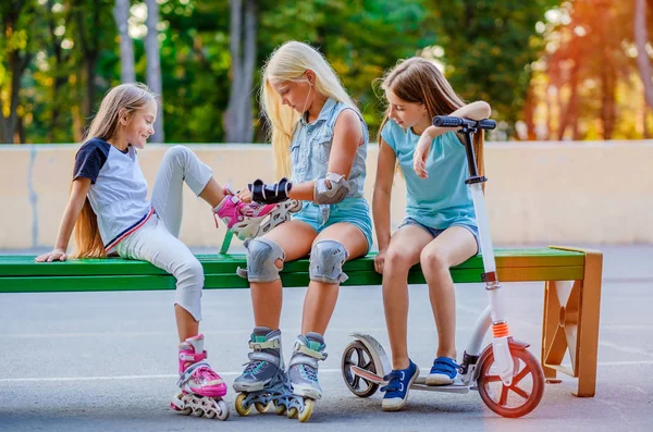 Små flickor att sätta på rullskridskor — Stockfoto