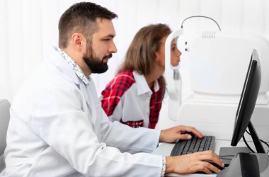 Genç kız udergoes tomograf üzerinde doktor ile göz araştırması