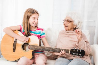 Büyükanne için gitar çalmaya torunu