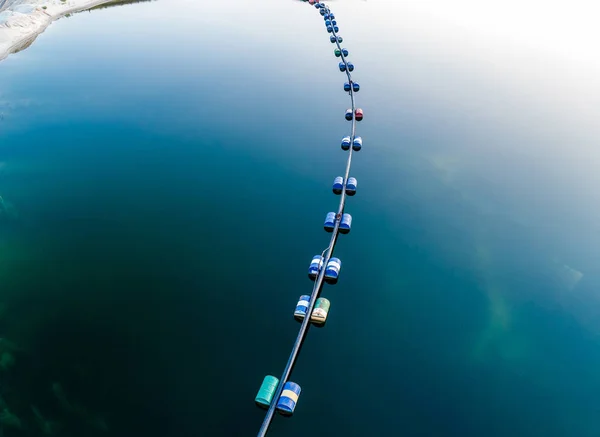 Aerial view of blue tube with barrels on the lake — Stock Photo, Image
