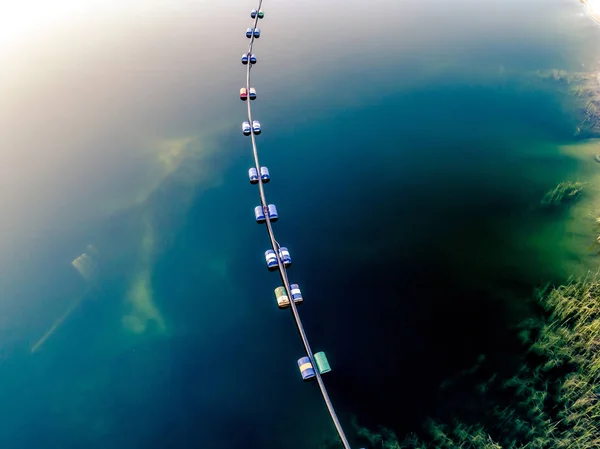 Aerial view of blue tube with barrels on the lake — Stock Photo, Image