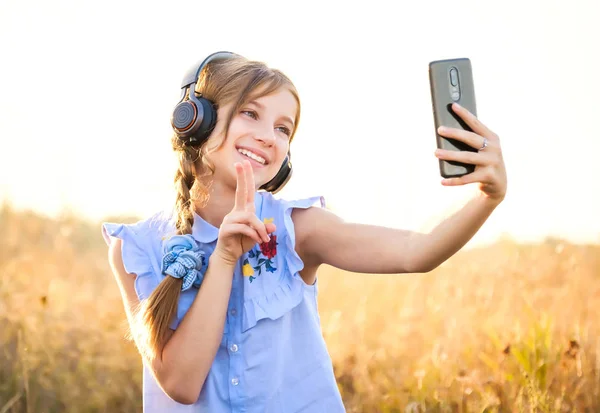 Adolescente com fones de ouvido tomando selfie bonito — Fotografia de Stock