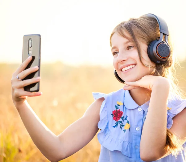 Adolescente chica con auriculares tomando lindo selfie — Foto de Stock