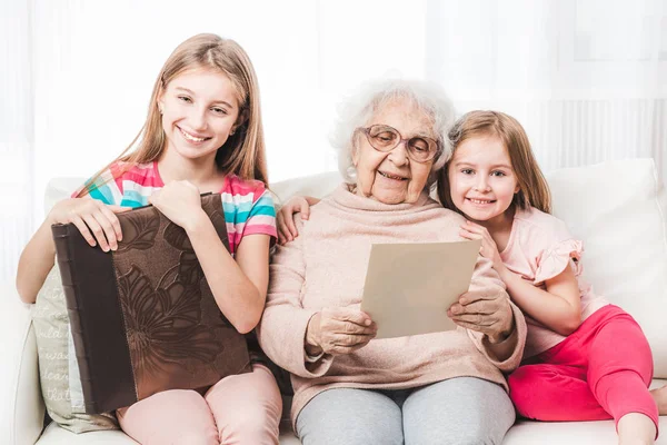 Sonriente abuela con nietas buscando — Foto de Stock