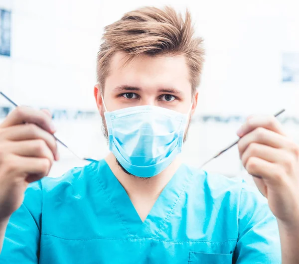 Οδοντίατρος σε μάσκα κρατώντας εργαλεία — Φωτογραφία Αρχείου