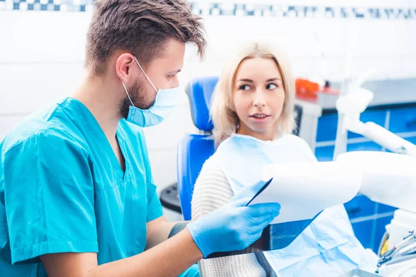 Dentista mostrando bloc de notas del paciente — Foto de Stock