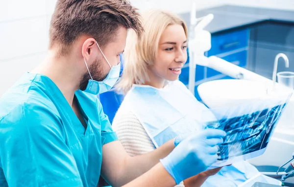 Dentista mostrando paciente radiografía dental — Foto de Stock