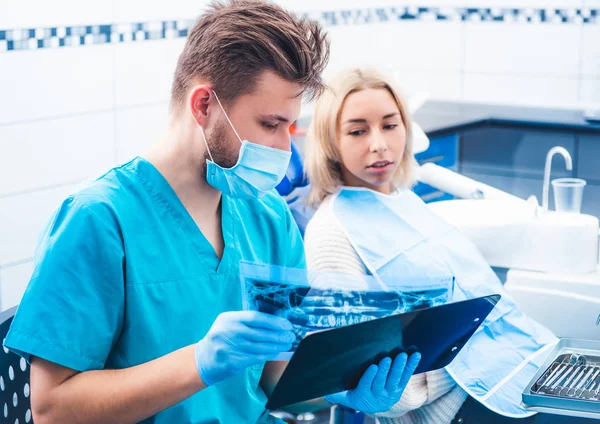 Dentista mostrando paciente radiografía dental — Foto de Stock