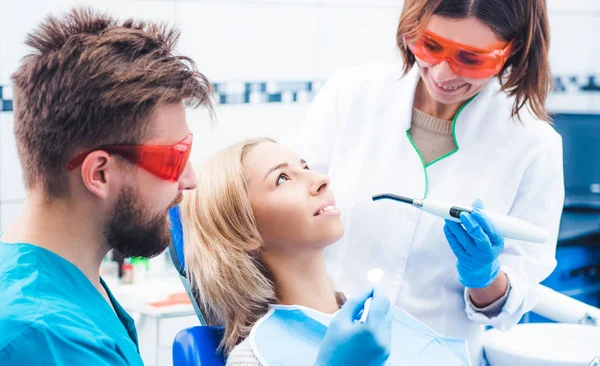 Dentists lighting dental seal with ultraviolet lamp — Stock Photo, Image