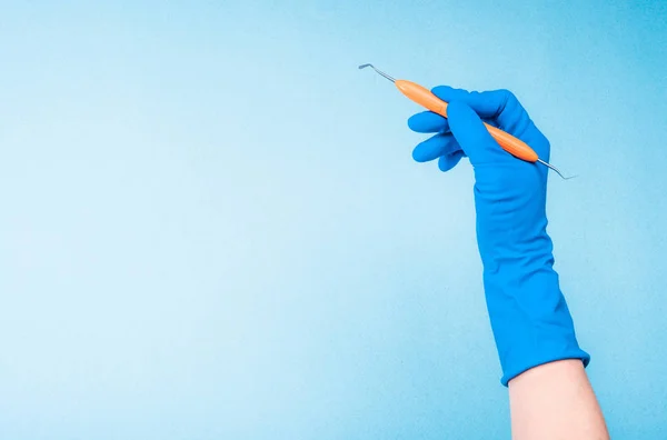 Hand i blå handske holding dental pincett — Stockfoto