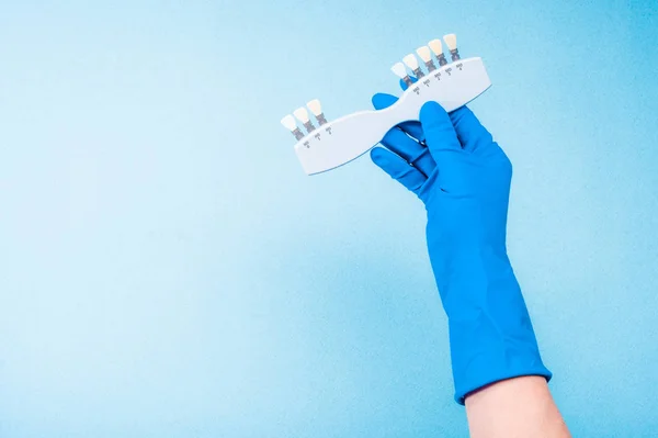 El mavi eldiven tutan diş renk paleti — Stok fotoğraf