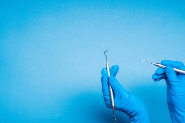 Mavi eldiven diş ameliyatı sopa tutan ellere