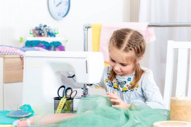 Küçük kız dikiş makinesinde el sanatları yapma