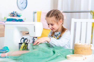 Küçük kız dikiş makinesinde el sanatları yapma