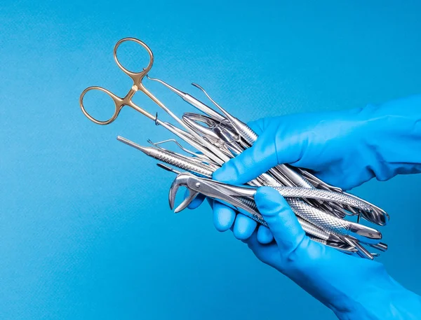 Main dans le gant bleu tenant chirurgie outils dentaires — Photo