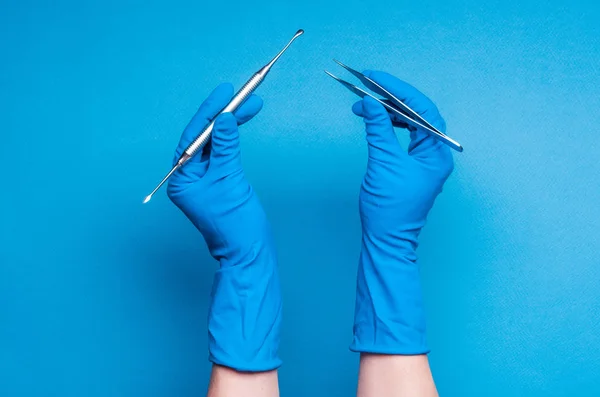 Mani in guanti blu con bastoni da chirurgia dentale — Foto Stock