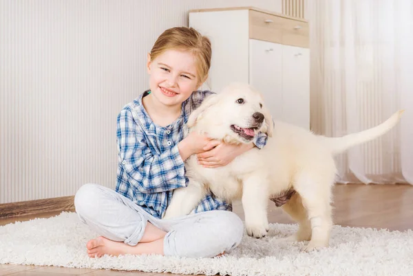 Улыбающаяся девушка обнимает щенка-ретривера — стоковое фото