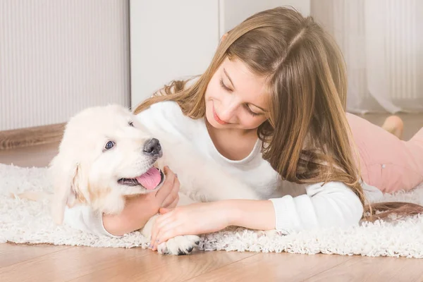 Teenage girl lying with retriever puppy — Stock Photo, Image