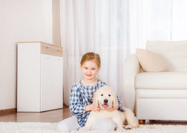 Улыбающаяся маленькая девочка, сидящая с маленьким щенком — стоковое фото
