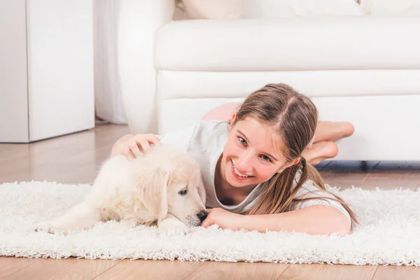 Fille couché avec mignon moelleux récupérateur chiot câlin — Photo