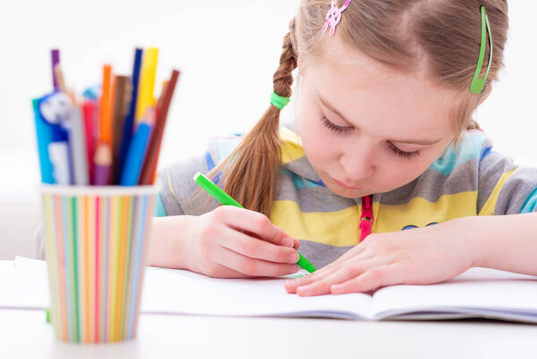 Young female pupil working in her copybook