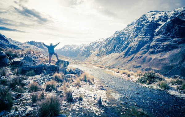 Hombre en las enormes piedras mirando el valle entre los Andes rocosos — Foto de Stock