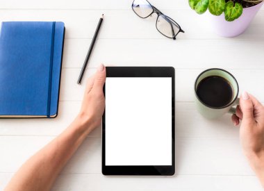 Tablet ve kahve bardağı tutan kızın üst görünümü