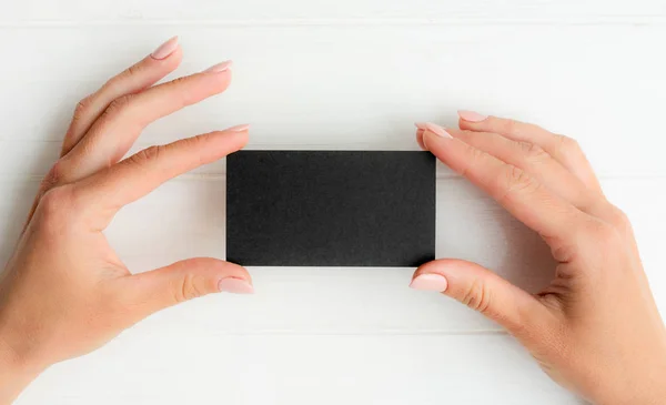 Черная визитка в женских руках — стоковое фото