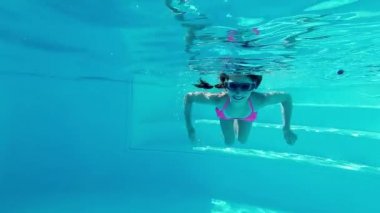 Sualtı yüzme havuzu içinde gülümseyen kız