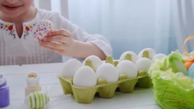 Genç kız yumurtaları boyuyor.