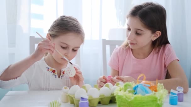 Две сестры раскрашивают яйца на Пасху — стоковое видео