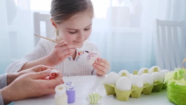 Pre-tiener meisje is kleuren eieren — Stockvideo