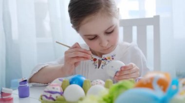 Genç kız yumurtaları boyuyor.