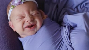 Menekşe battaniyede uyuyan yeni doğan bebek