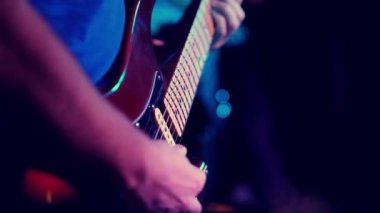 Elektro gitarda akorlar çalan bir müzisyen.