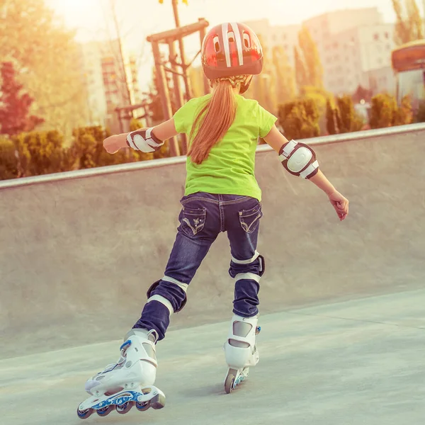 Vista trasera de la niña en casco en patines —  Fotos de Stock