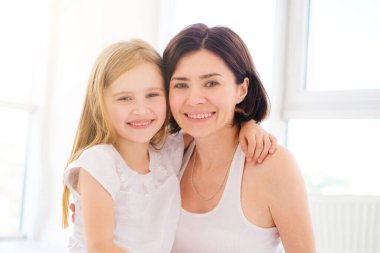 Anne ve küçük kızı sarılıyor.