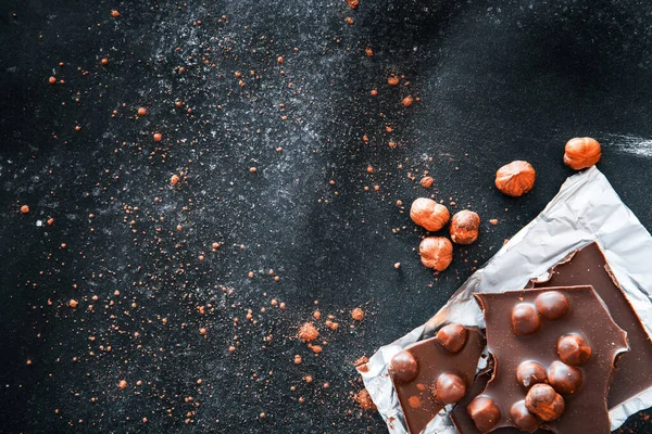 Chocolate y nueces sobre mesa negra — Foto de Stock