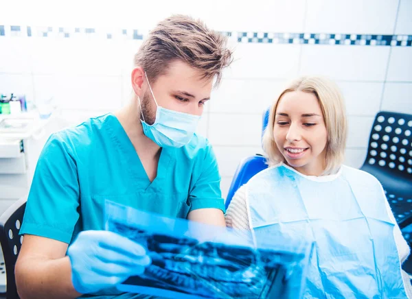 Dentista mostrando paciente radiografía dental — Foto de Stock