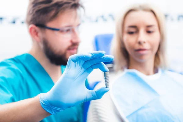 Dentista mostrando modelo de implante cinza — Fotografia de Stock