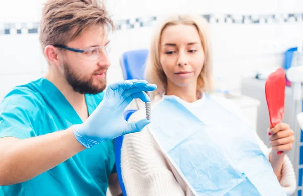 Dentista mostrando modelo de implante cinza — Fotografia de Stock