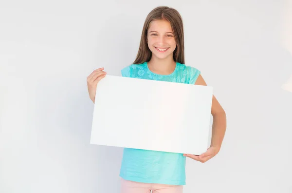 Menina mostrando tela branca com espaço de cópia — Fotografia de Stock