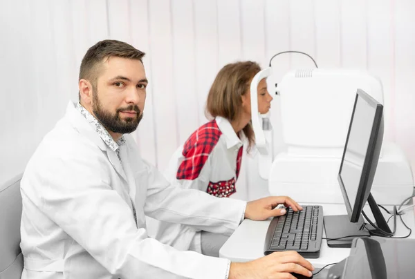 Girl udergoes eye survey with doctor on tomograph — Stock Photo, Image