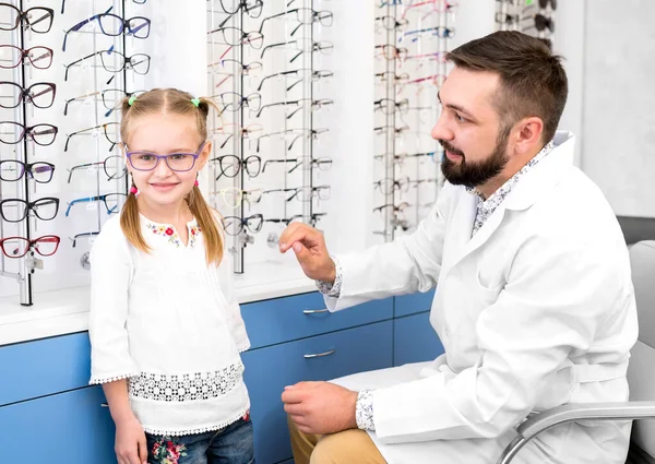 Chica y médico elegir gafas — Foto de Stock